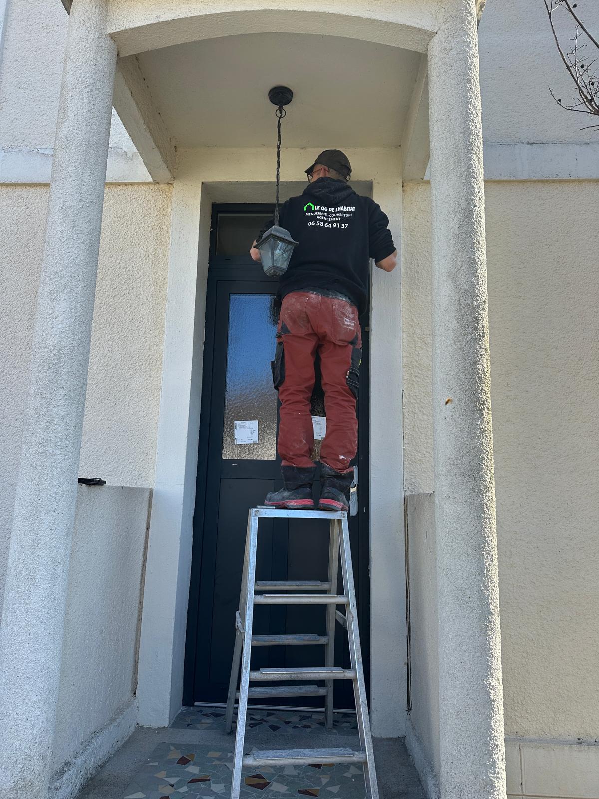 Artisan posant une porte d'entrée sur une maison à Troyes, Aube