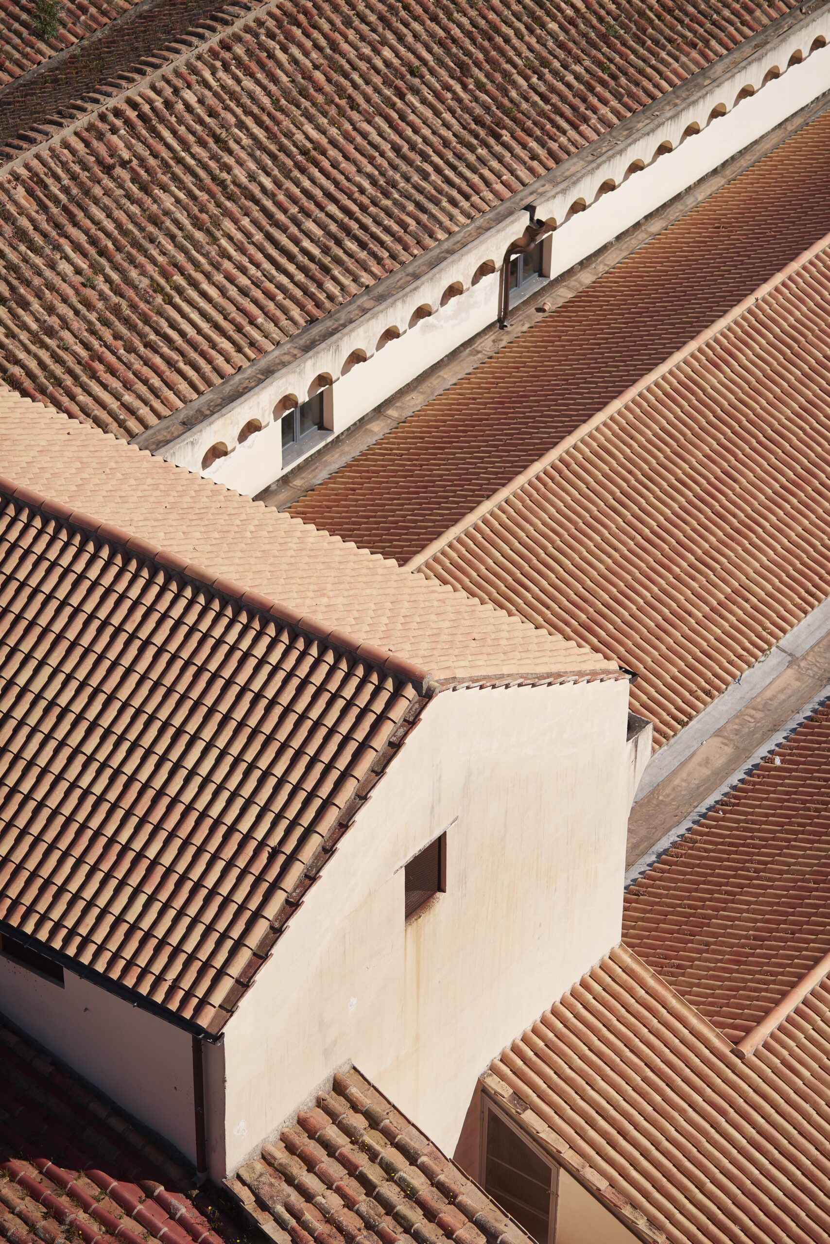 A high angle view of white buildings with red roofs under sunlight