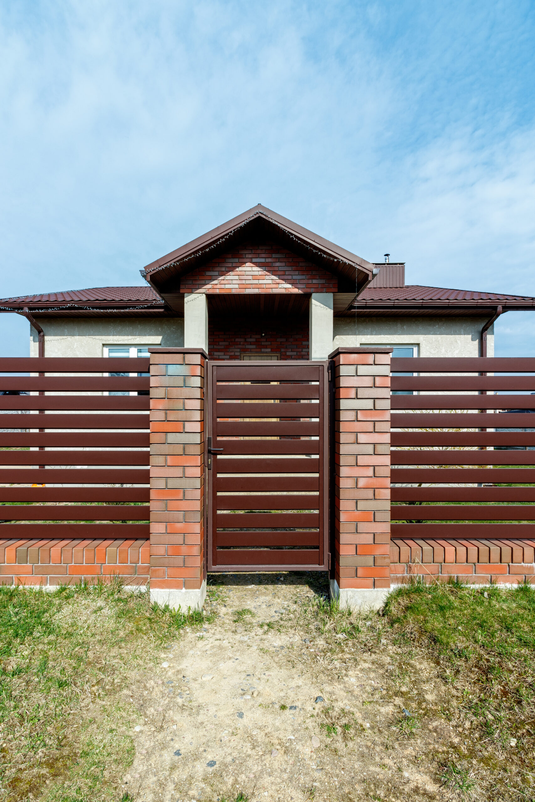 Fragment of a modern fence lined with decorative bricks in the old style.